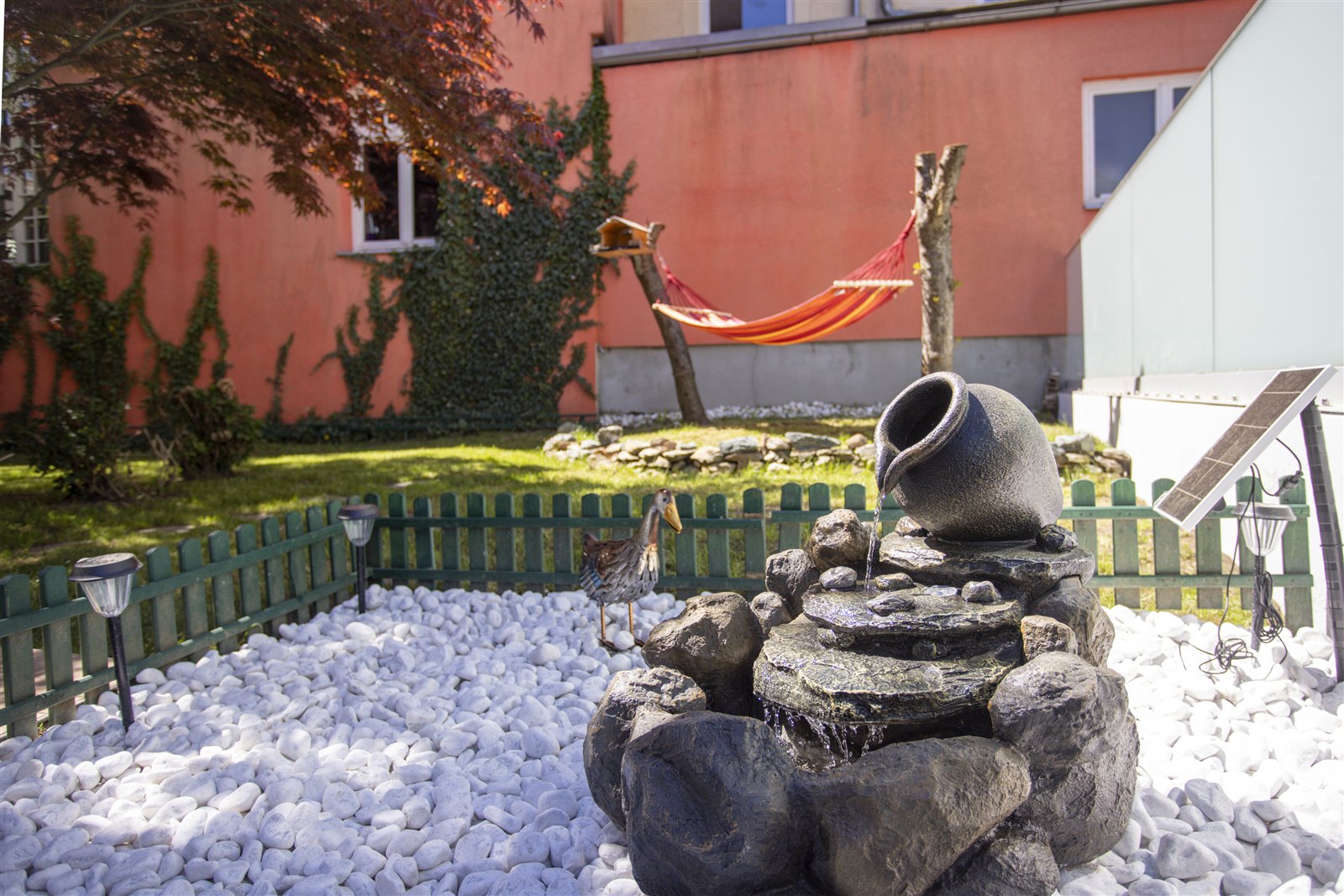 Garten der Villa 216 mit Brunnen und Hängematte